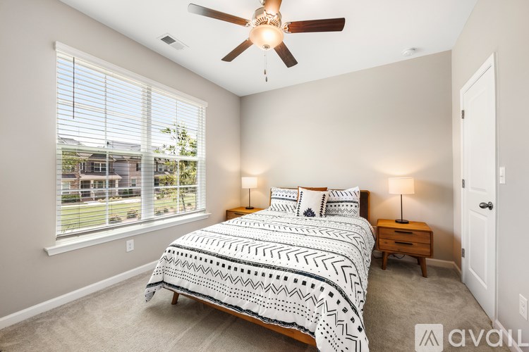 A bedroom with a large bed and a ceiling fan.