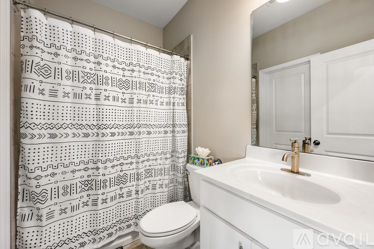 A white bathroom with a shower curtain and a toilet.