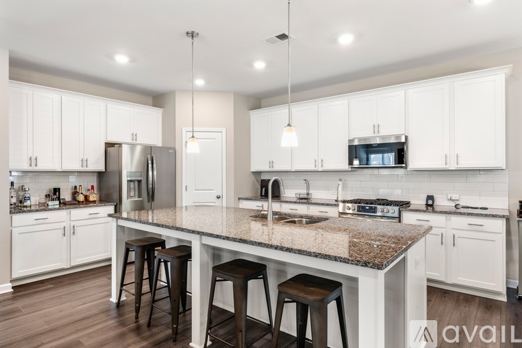 A kitchen with a granite countertop and white cabinets.