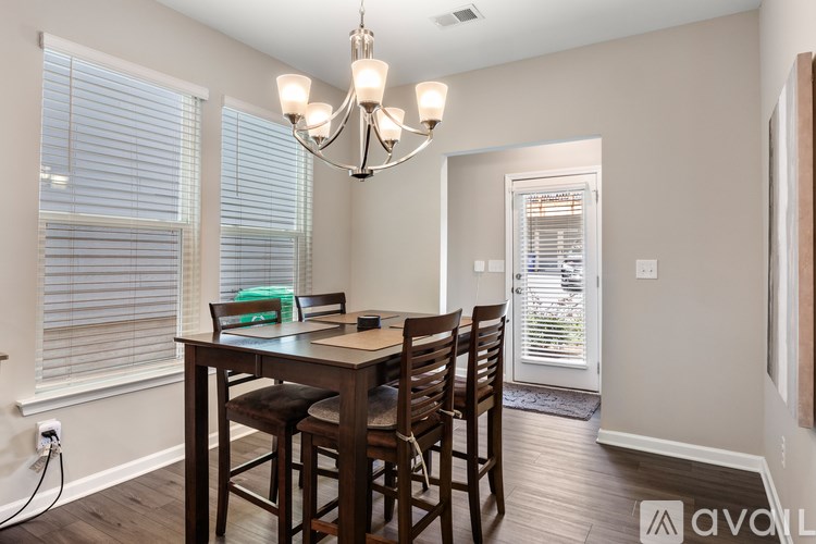 A dining room with a wooden table and chairs.
