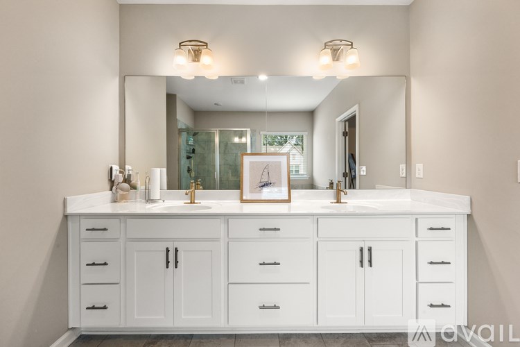 A bathroom with a white vanity and a mirror above it.