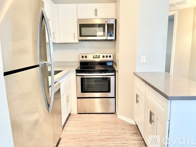 A kitchen with a stainless steel refrigerator, oven, and microwave.