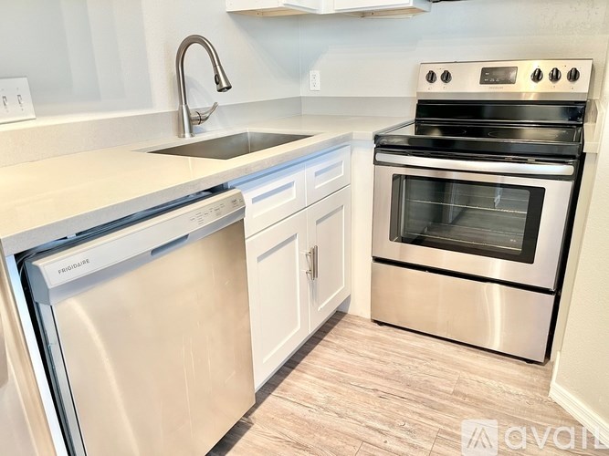 A modern kitchen with a stainless steel dishwasher and oven.