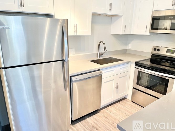 A kitchen with a stainless steel refrigerator, dishwasher, and oven.