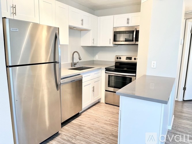 A modern kitchen with stainless steel appliances and white cabinets.