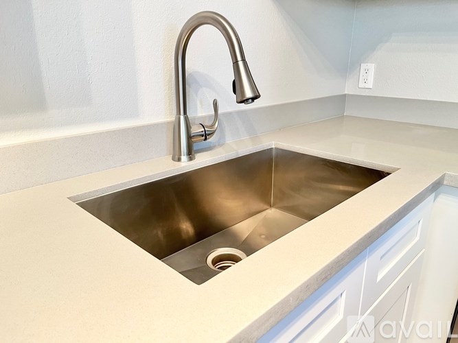 A modern kitchen sink with a chrome faucet.