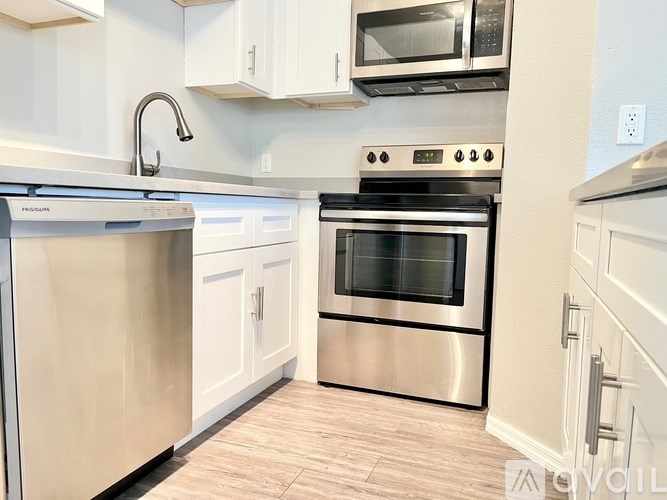 A modern kitchen with stainless steel appliances and white cabinets.