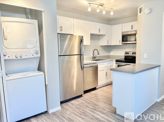 A kitchen with a stainless steel refrigerator, oven, and microwave.