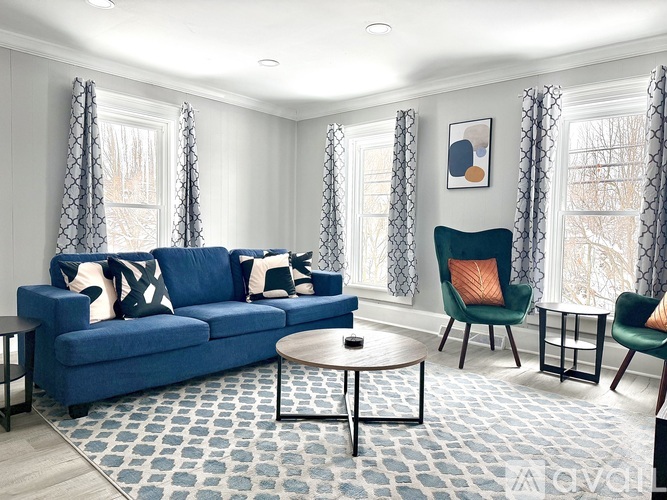 A living room with a blue couch, two chairs, and a coffee table.
