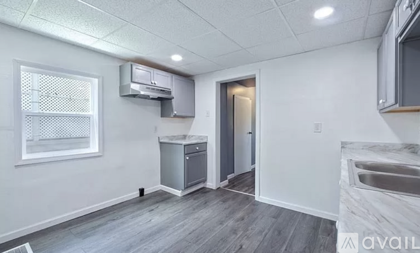 A kitchen area with a sink, a window, and a microwave.