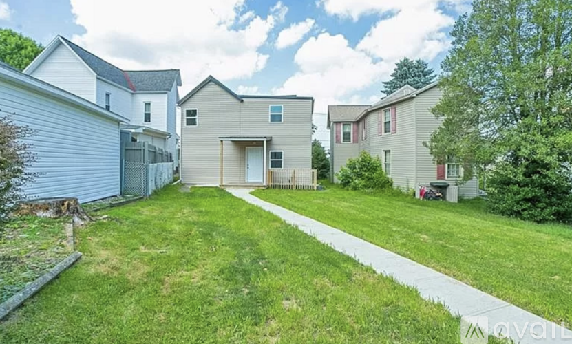 A house with a garage is surrounded by a grassy area.