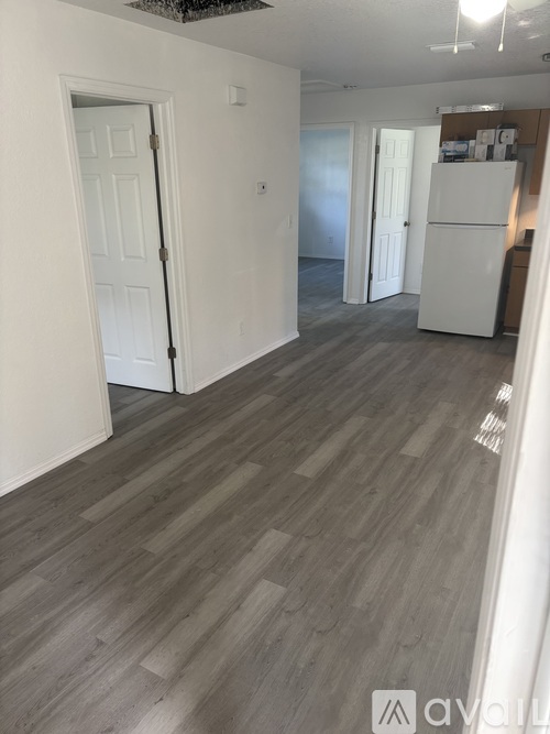 A room with a white door and a white fridge.