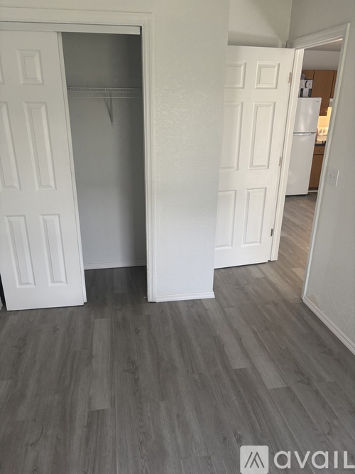 A room with a white door and a wooden floor.