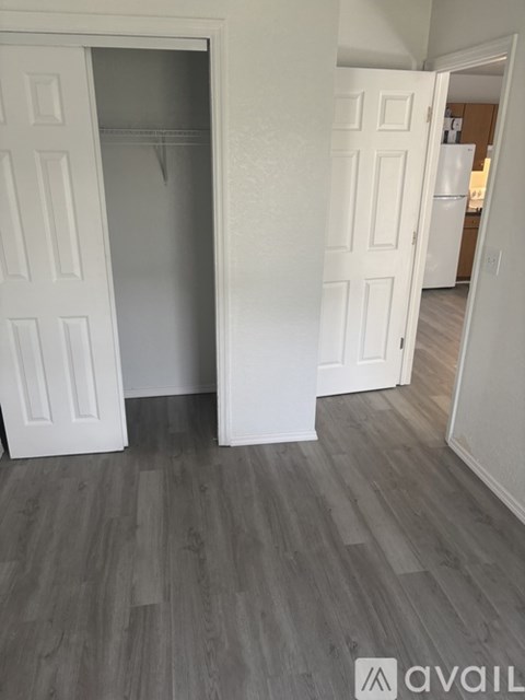 A room with a white door and a wooden floor.