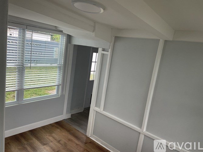 A room with a window and a wall with a white frame.