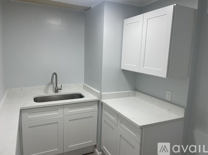 A kitchen with white cabinets and a sink.