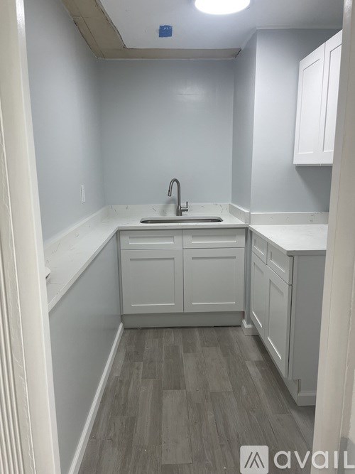 A kitchen with white cabinets and a sink.