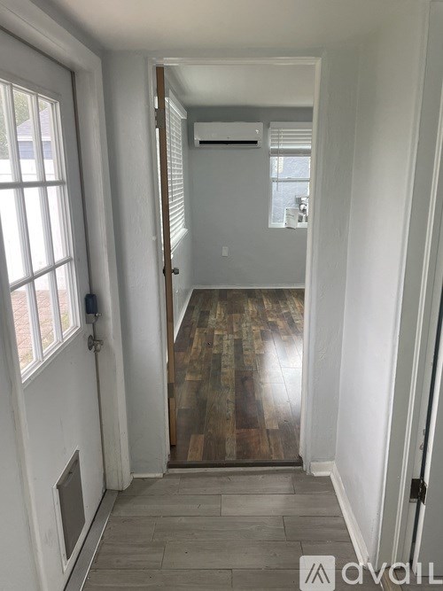 A hallway with a door on the left and a window on the right.