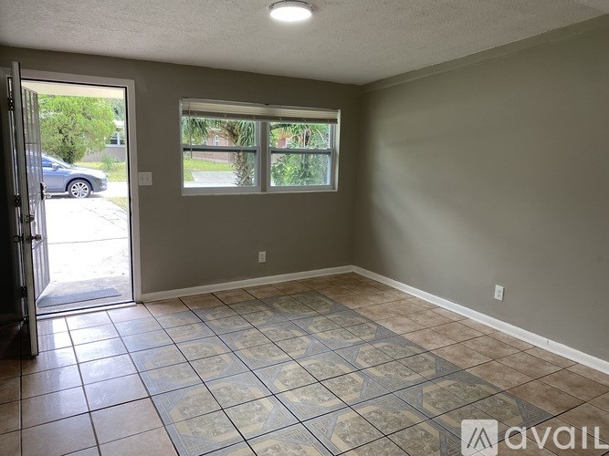 A room with a tiled floor and a window overlooking a street.