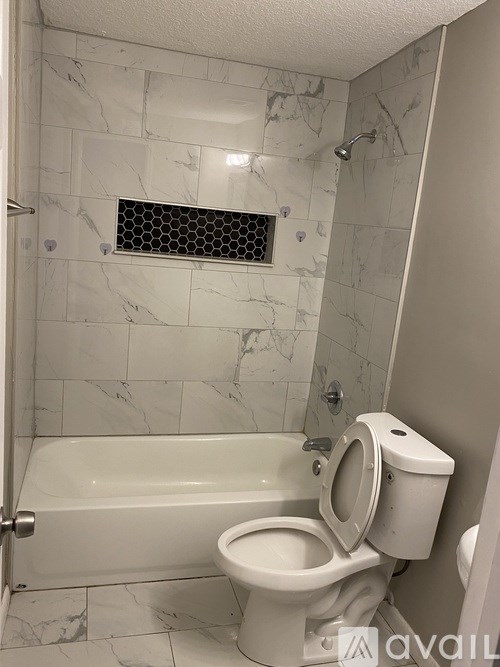 A white toilet in a bathroom with marble tiles.