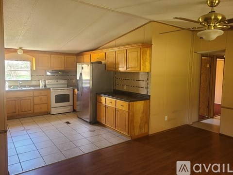 A kitchen with wooden cabinets and a black countertop.