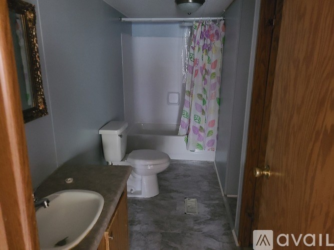 A small bathroom with a toilet, sink, and shower.