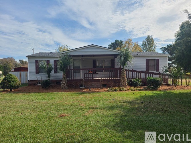 A house with a white exterior and a covered patio is for sale.