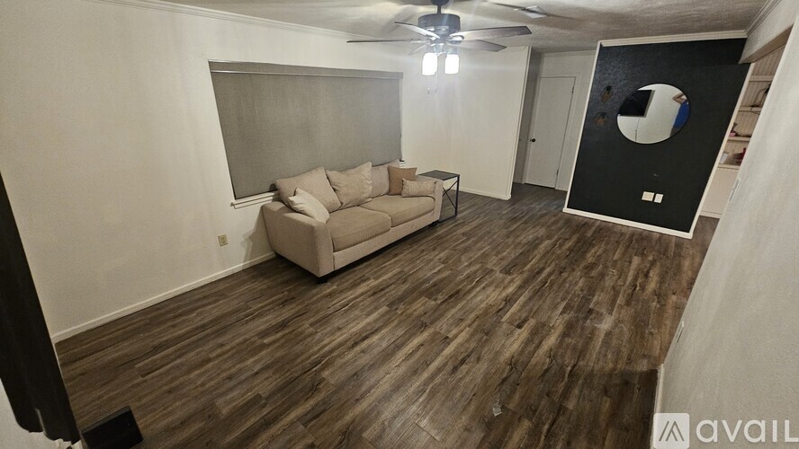 A living room with a couch and a ceiling fan.