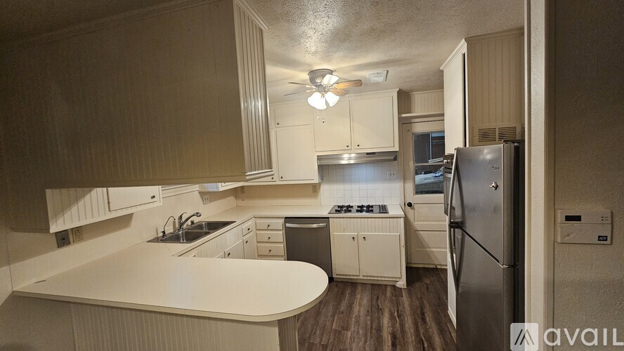 A kitchen with white countertops and wooden cabinets.