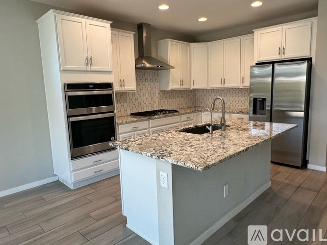 A kitchen with granite countertops and stainless steel appliances.