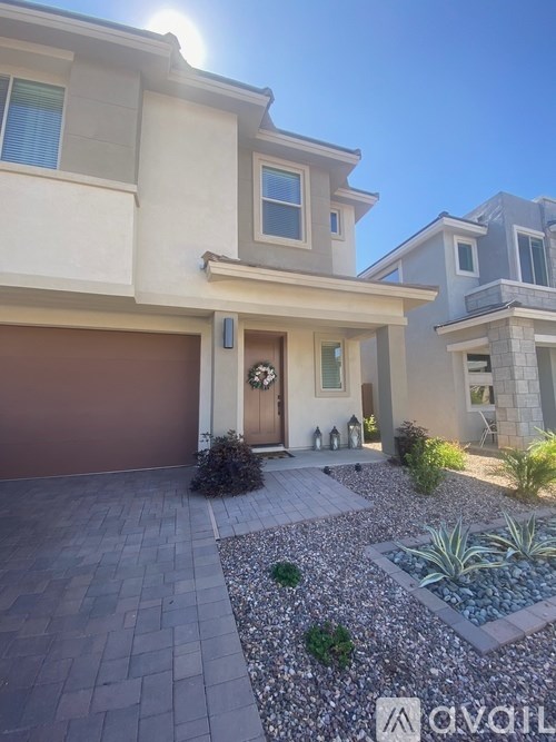A house with a brown garage door and a front door with a wreath on it.