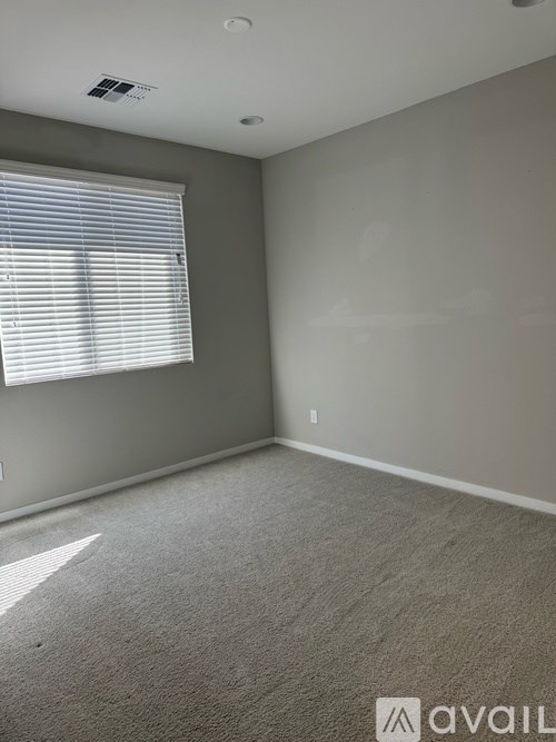 A room with a window and carpeted floor.