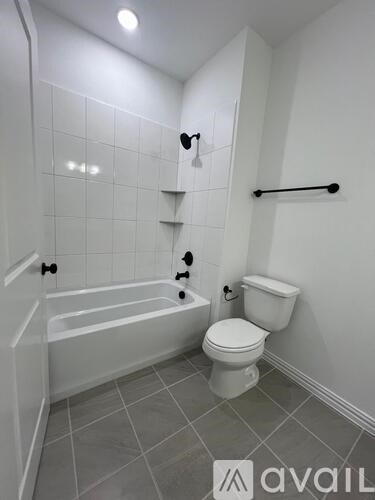 A white bathroom with a toilet, tub, and towel rack.