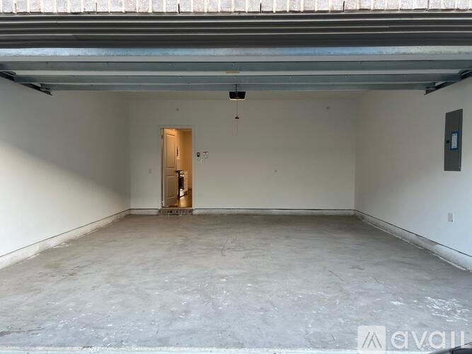 A spacious garage with a door and a wall-mounted electrical box.
