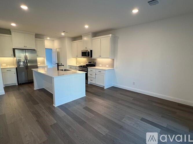 A kitchen with a refrigerator, microwave, and oven.