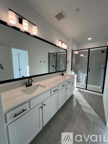 A bathroom with a sink, mirror, and tiled floor.