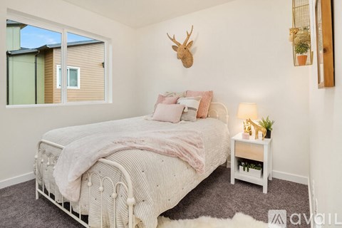 A bedroom with a large bed and a deer head mounted on the wall.