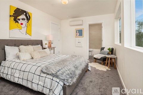 A bedroom with a large bed and a painting on the wall.