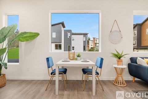 A dining room with a white table and blue chairs.