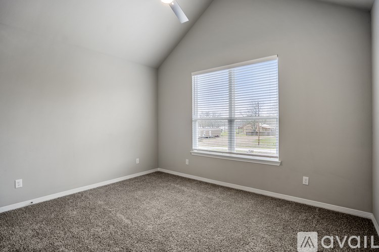 A room with a carpeted floor and a window with blinds.