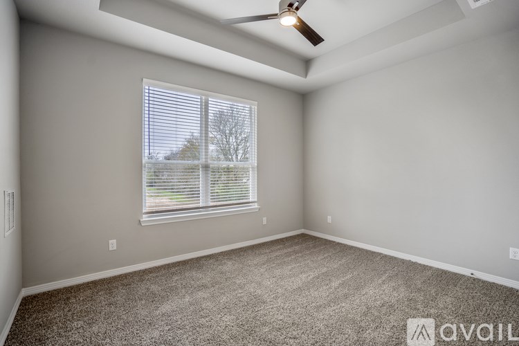 A room with a ceiling fan and a window with blinds.