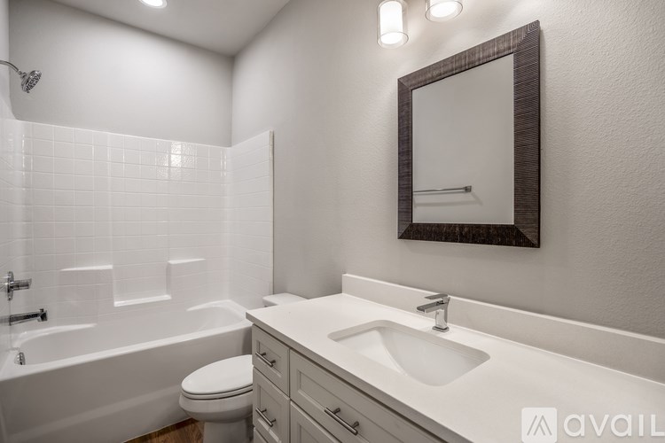 A bathroom with a white sink, toilet, and bathtub.