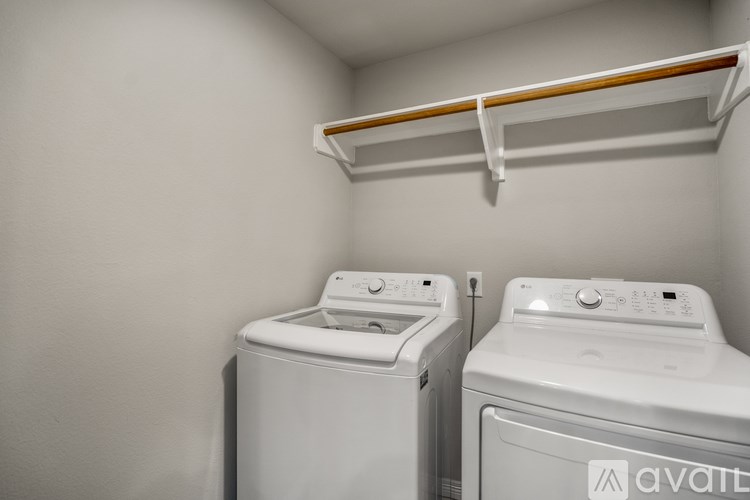 Two white front loading washing machines in a small laundry room.