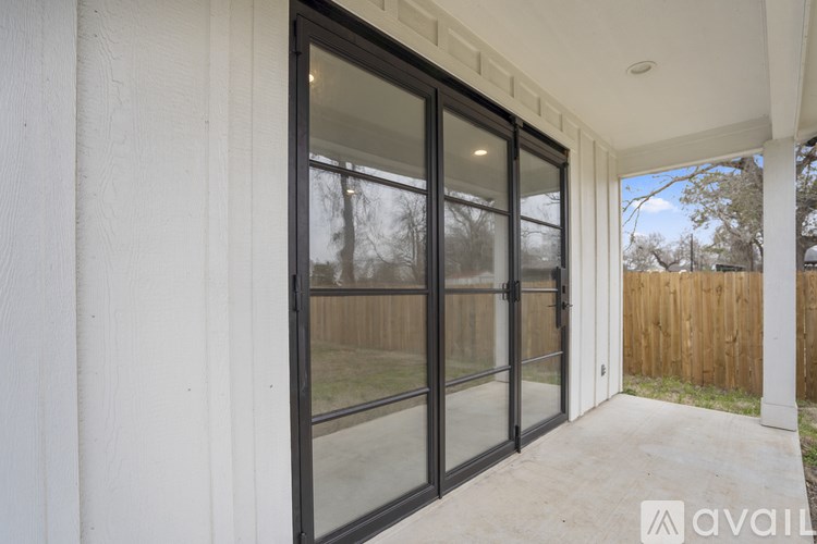 A patio with a sliding glass door and a white wall.