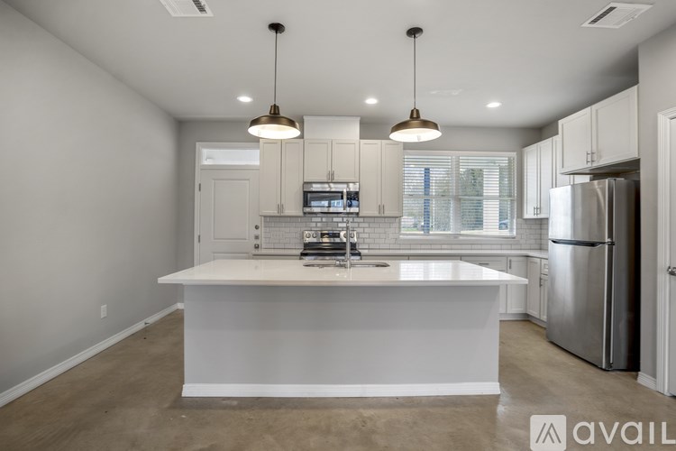 A modern kitchen with a white island and stainless steel appliances.