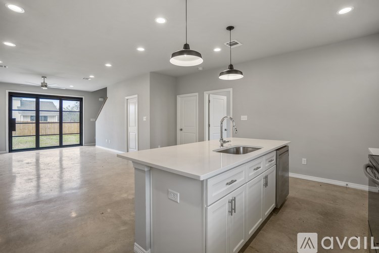 A kitchen with white cabinets and a sink under a window.