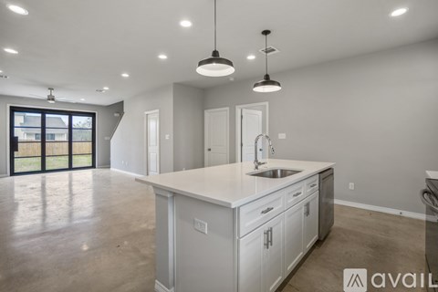 A kitchen with white cabinets and a sink under a window.