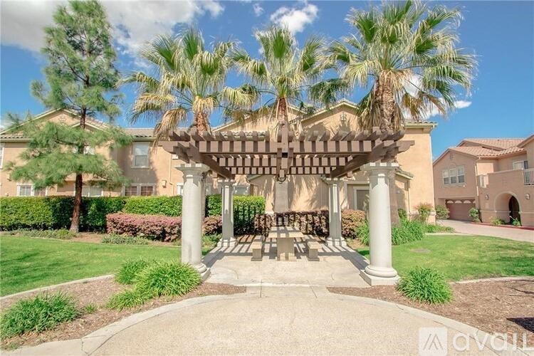 A large house with a patio and a tree in front.