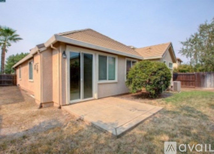 A house with a brown roof and tan walls is for sale.