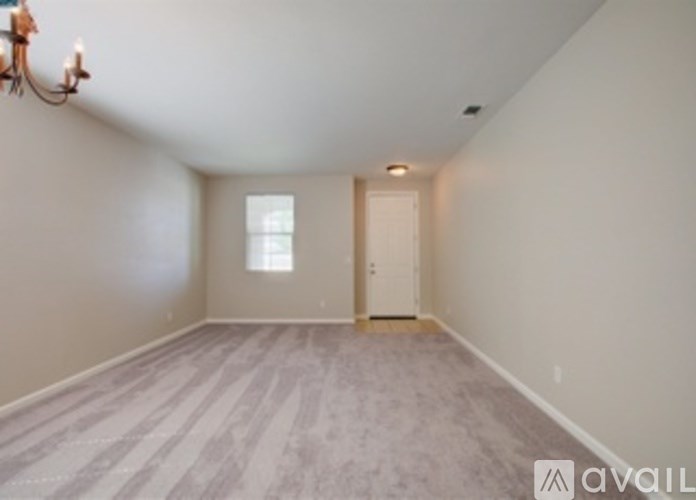 A room with a chandelier and a window.